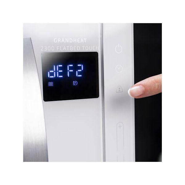Magnetron bedieningspaneel met 'dEF2'. Een vinger drukt op een knop. Wit apparaat, close-up.