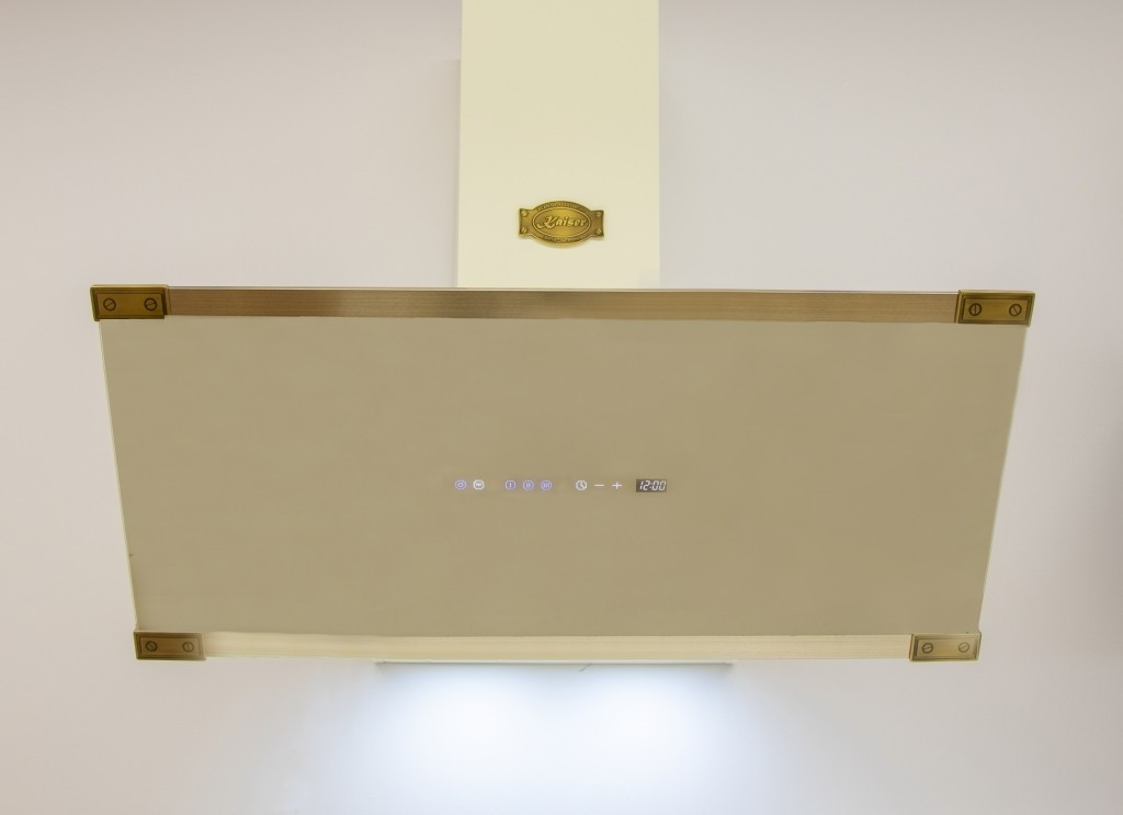 Cremefarbene Küchenhaube mit goldenen Akzenten und Digitalanzeige.