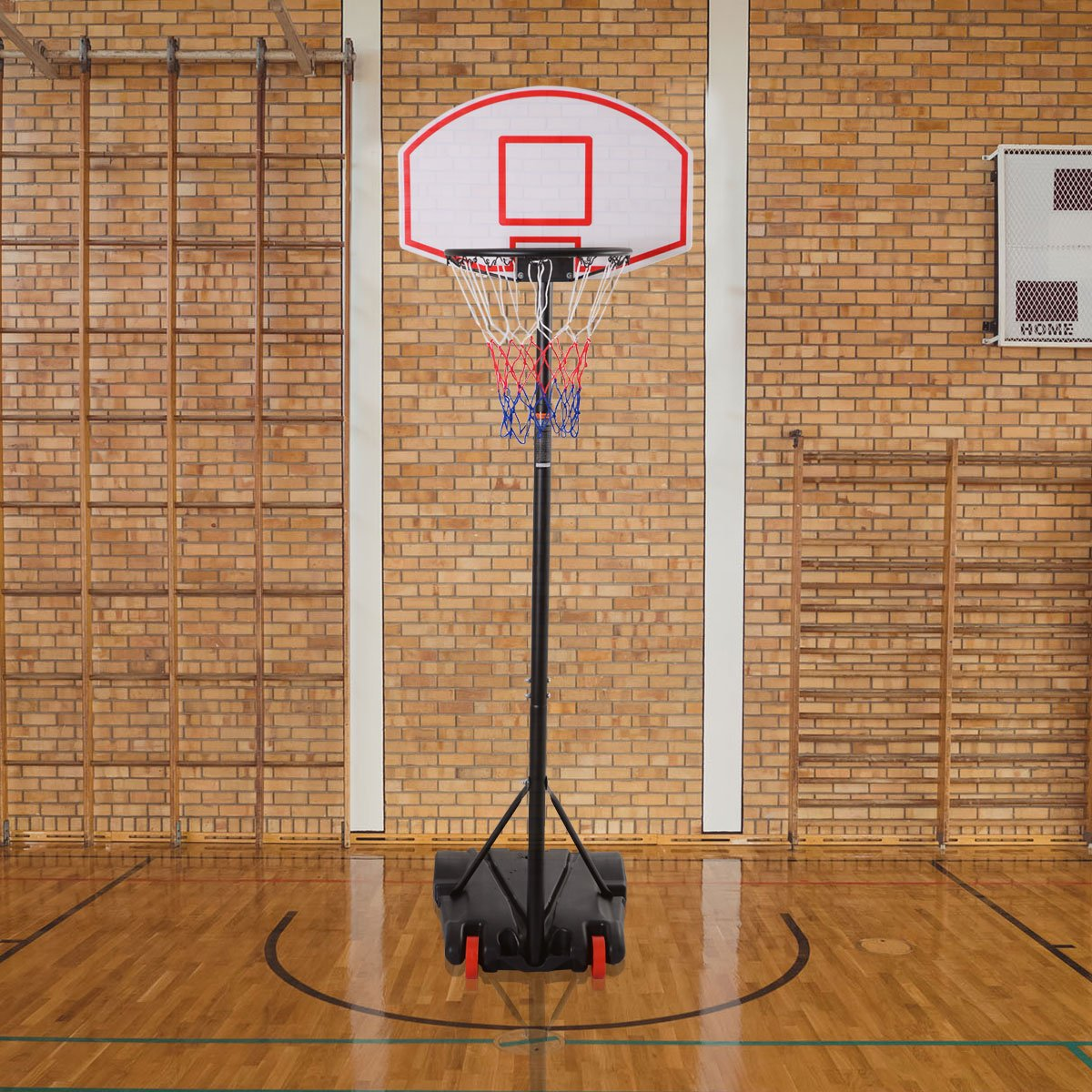 Basketballkorb in Sporthalle mit Holzboden, Backsteinwänden und Anzeigetafel.
