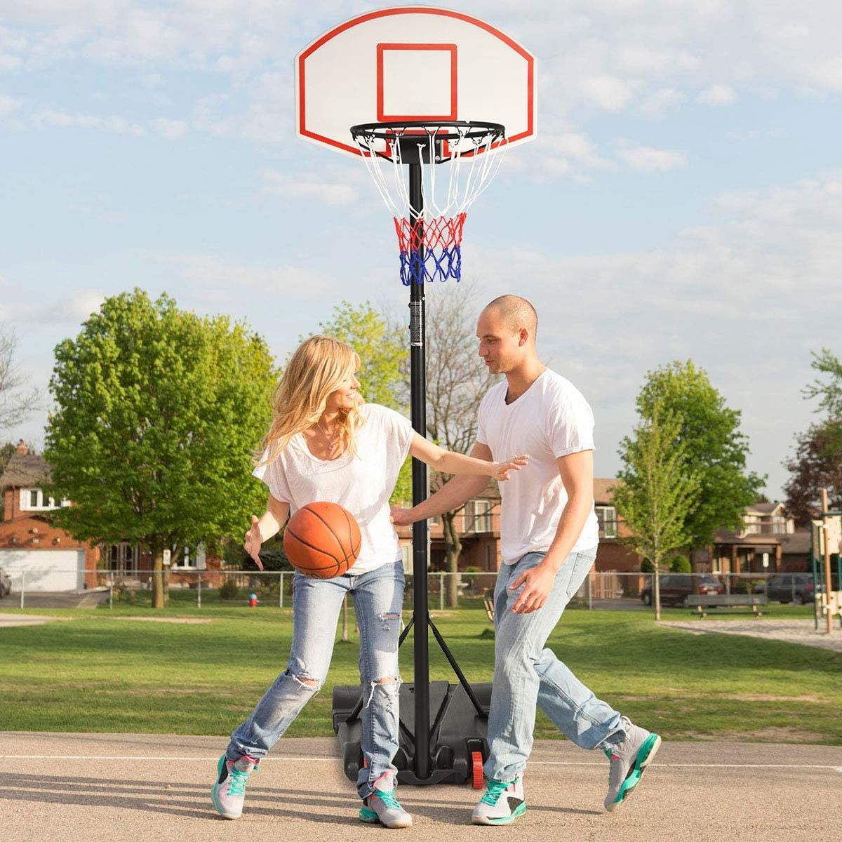 Zwei Leute spielen Basketball. Einer dribbelt, der andere verteidigt. Basketballkorb.
