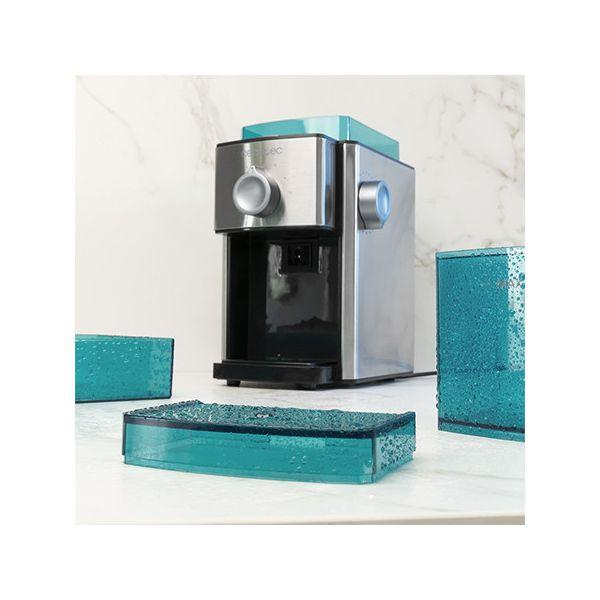 Wytwornica lodu ze stali nierdzewnej z niebieskimi tacami na lód na białym marmurze.