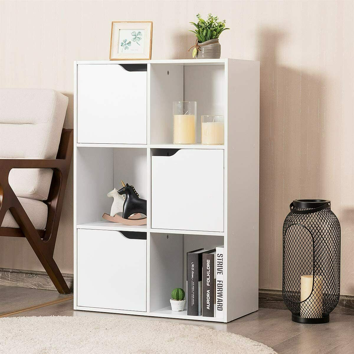 Weißer Holzschrank mit sechs Fächern. Es gibt dekorative Gegenstände und Bücher darin.
