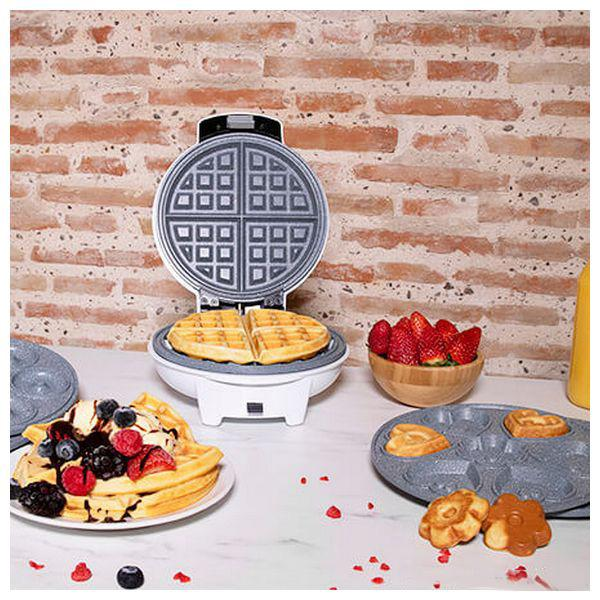 Waffeleisen mit Waffeln. Waffeln auf einem Teller, mit Belag und eine Form mit Waffeln.