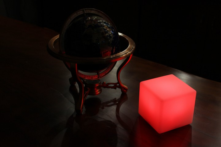 Globus, Würfel Licht und der dunkle Hintergrund auf Holztisch.