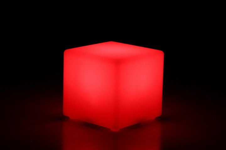 Rotes würfelförmiges Licht mit schwarzem Hintergrund. Der Würfel leuchtet und seine Kanten sind sichtbar.