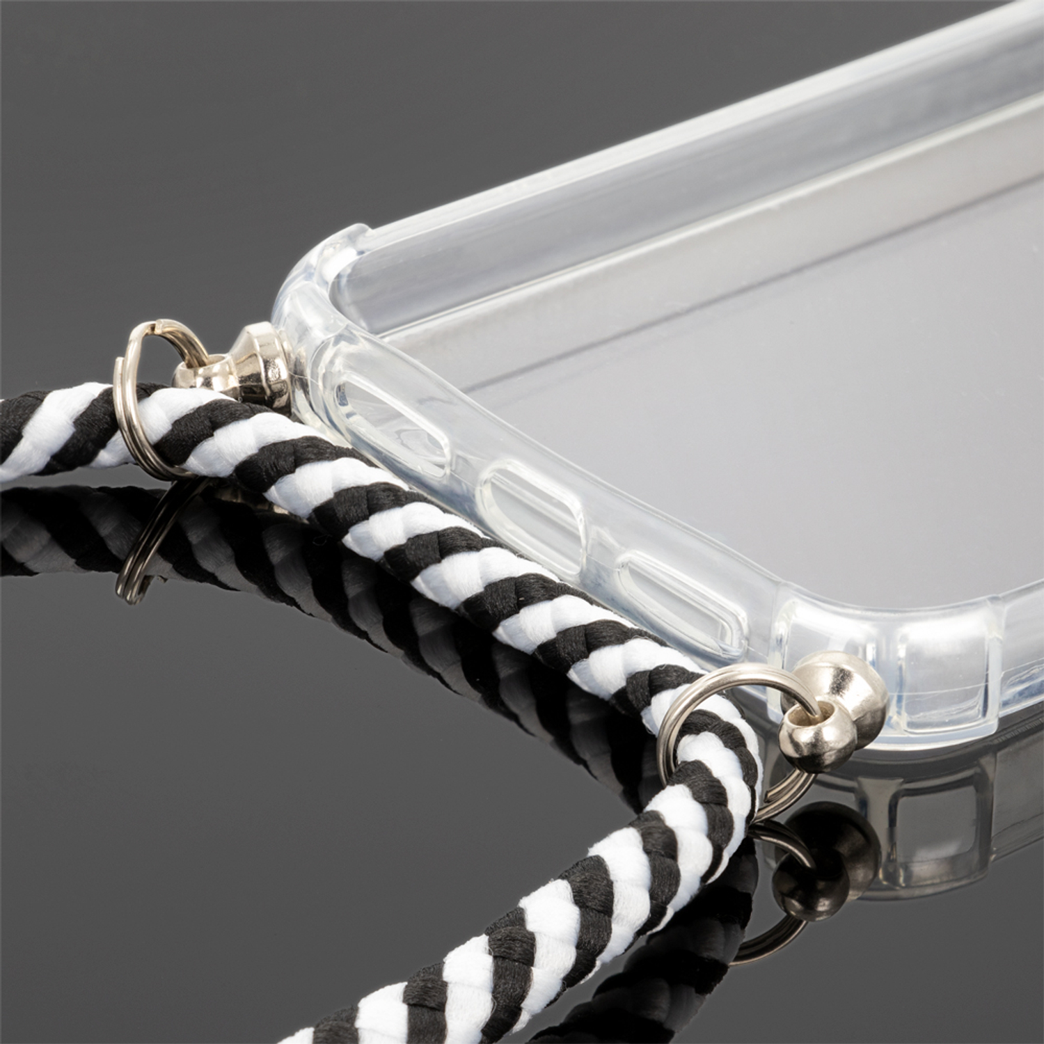 Eine transparente Handyhülle mit einem schwarz-weißen Schlüsselband. Die Hülle reflektiert Licht und zeigt eine glänzende Oberfläche.