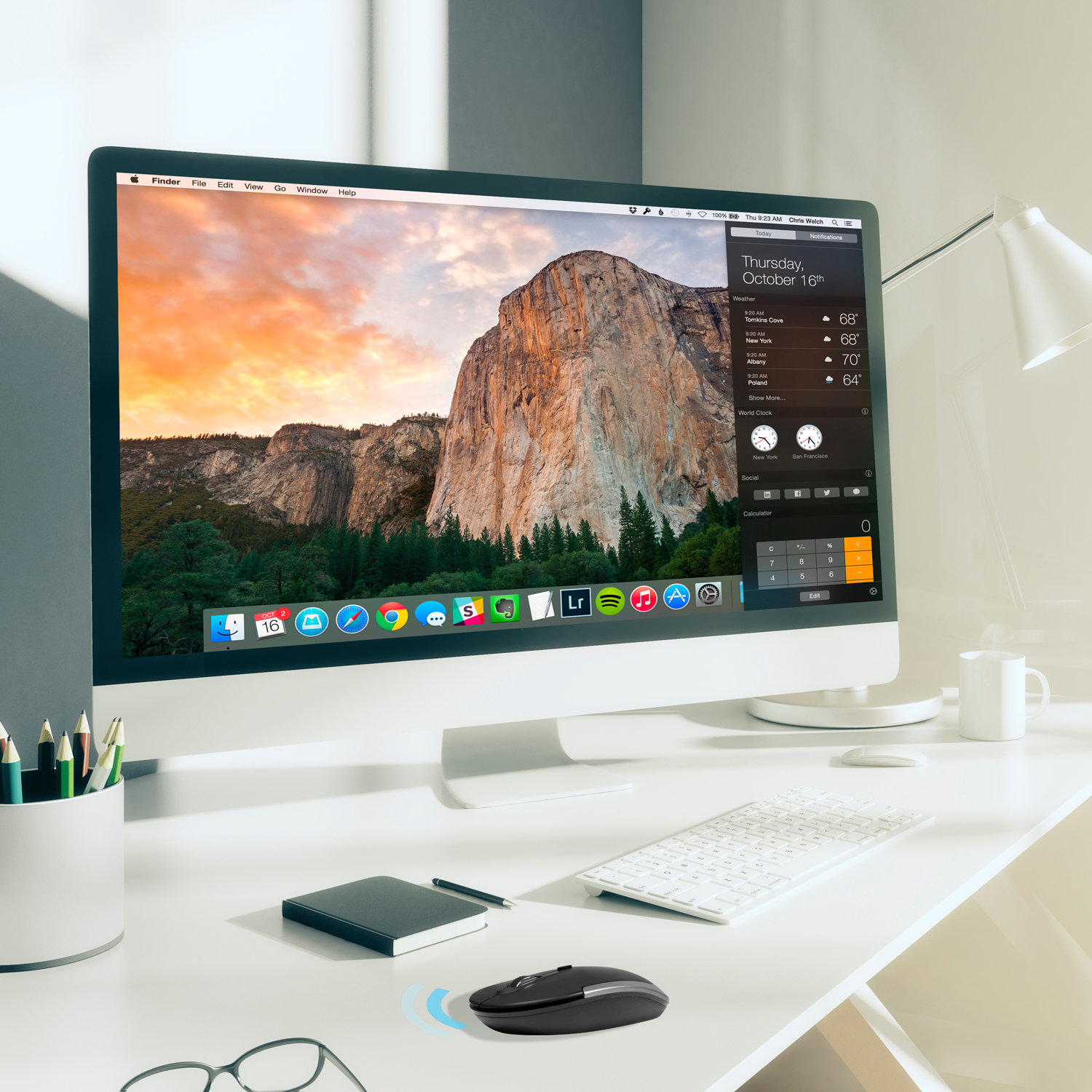 Computer-Setup auf einem weißen Schreibtisch. Enthält einen Monitor, der eine Berglandschaft zeigt.