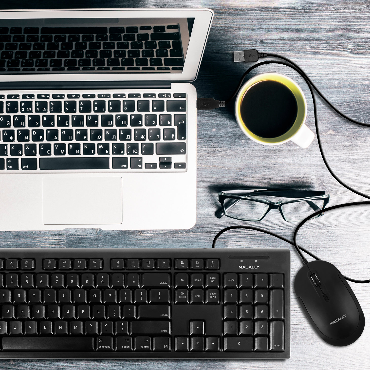 Laptop, Tastatur, Maus und eine Tasse Kaffee auf einem Holztisch. USB ist angeschlossen.