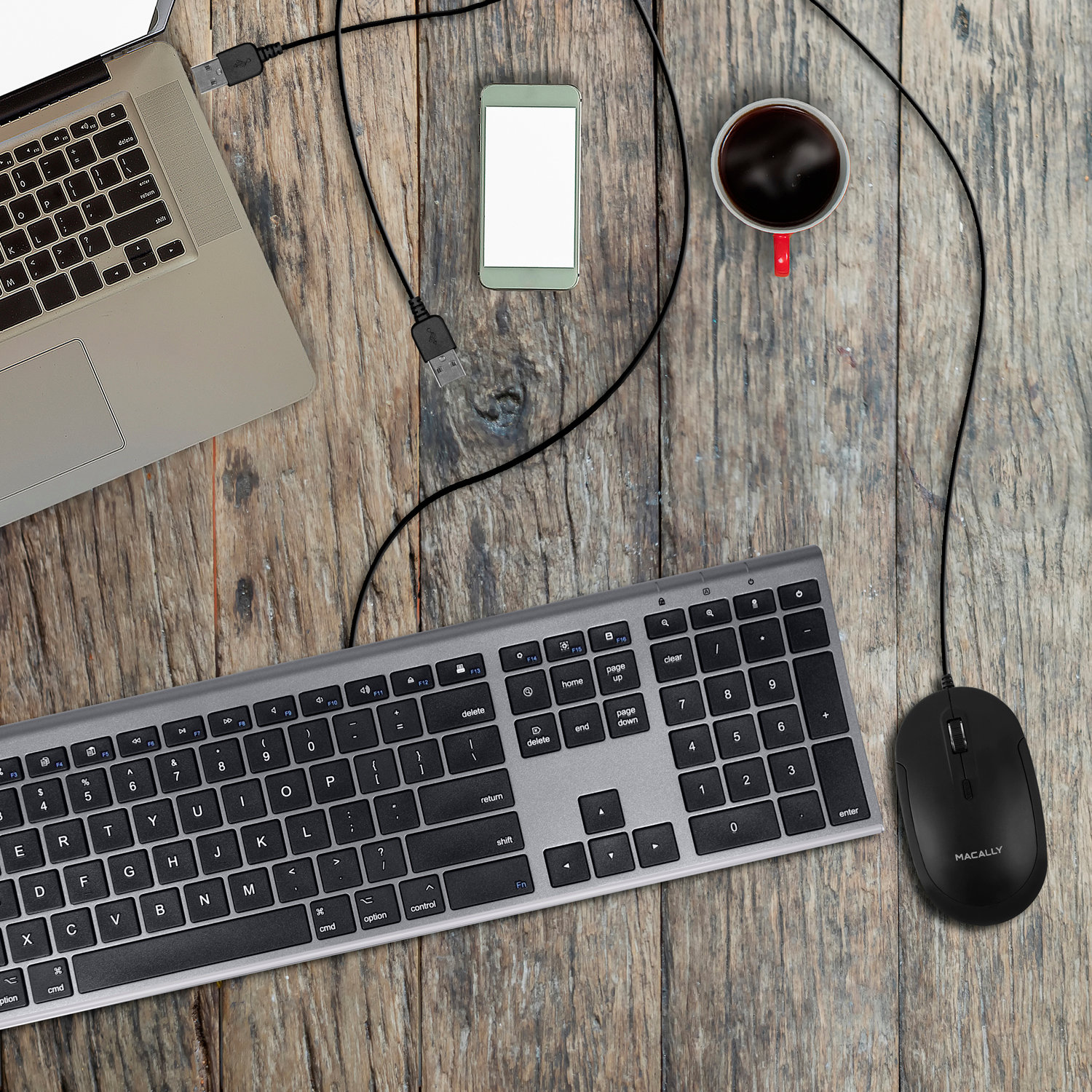 Draufsicht auf einen Schreibtisch mit Laptop, Tastatur, Maus, Telefon und einer Tasse Kaffee.