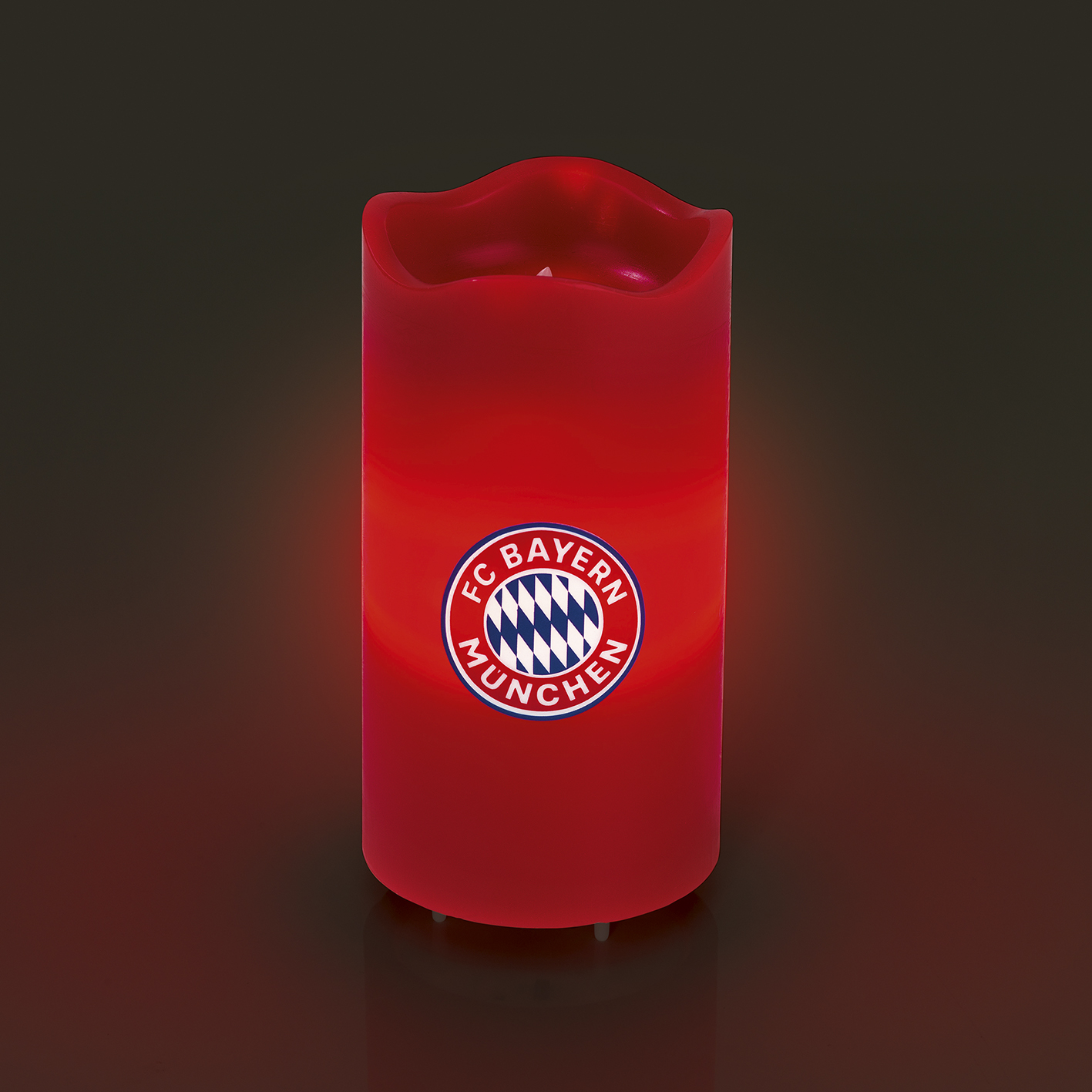 Rote Kerze mit dem FC Bayern München Logo. Die Kerze hat ein warmes, leuchtendes Licht.