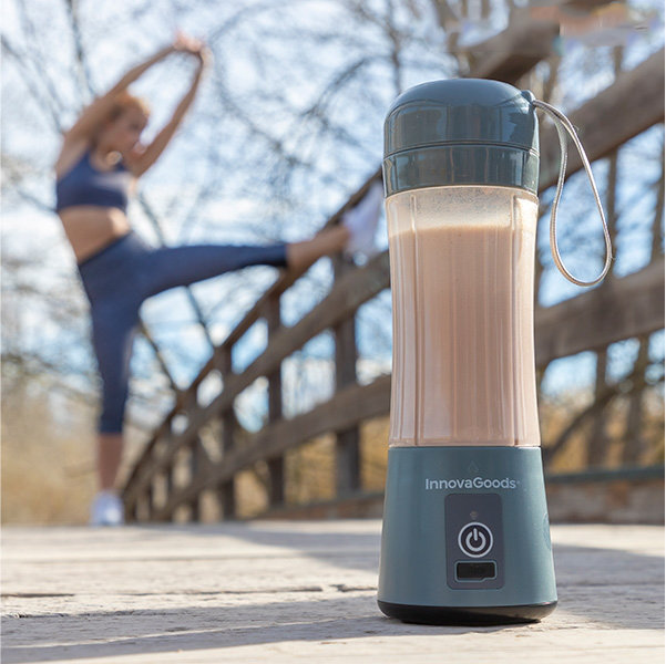 Kobieta rozciąga się w pobliżu mostu, a blender stoi na drewnianej podłodze na pierwszym planie.