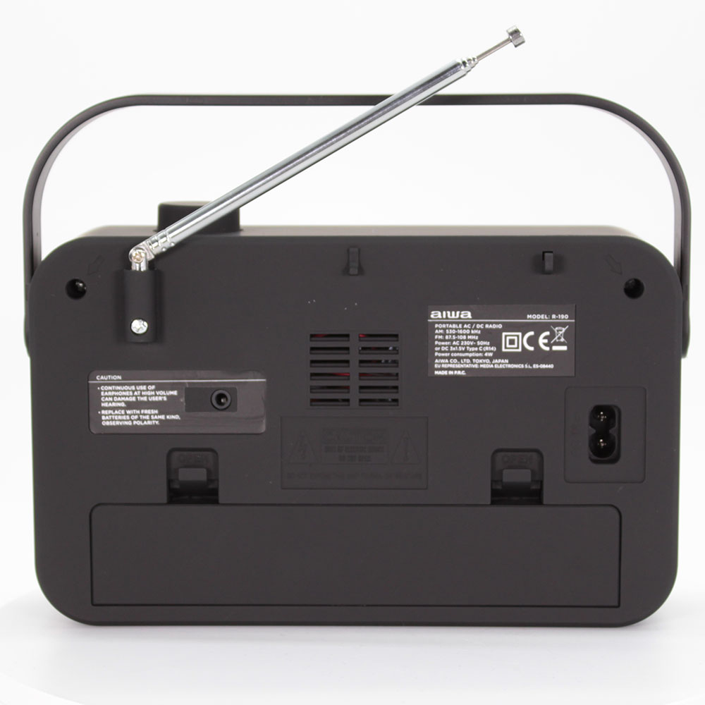 Czarne radio z anteną i uchwytem. Tył pokazuje szczegóły i etykiety na białej powierzchni.