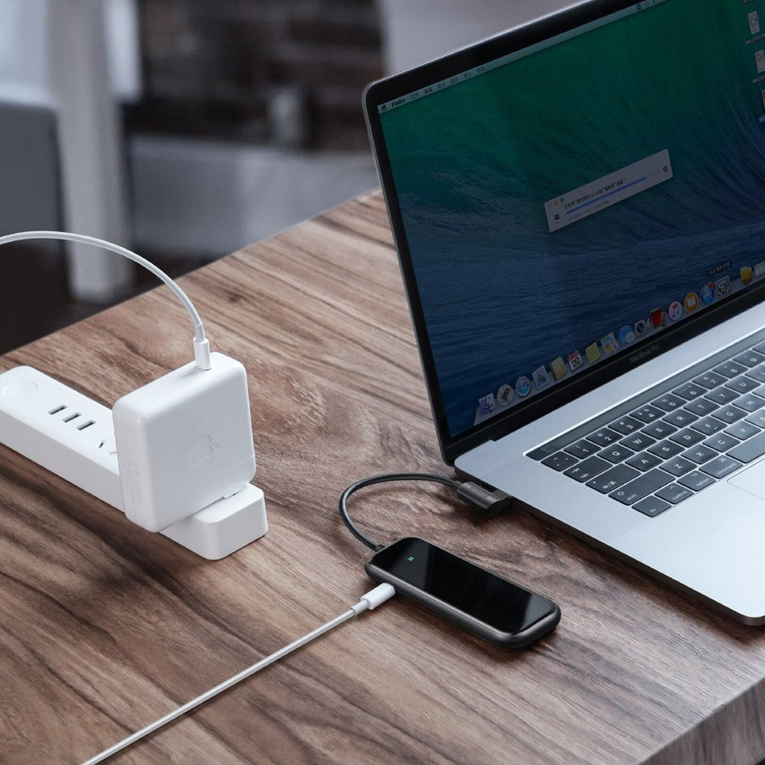 Laptop mit Steckdosenleiste und Adapter. Ein Gerät ist mit dem Laptop verbunden.
