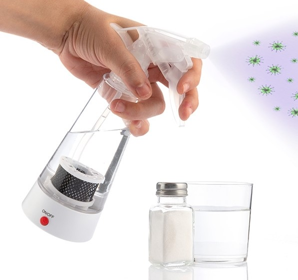 Mano rociando con botella transparente, cerca de vaso y sal.