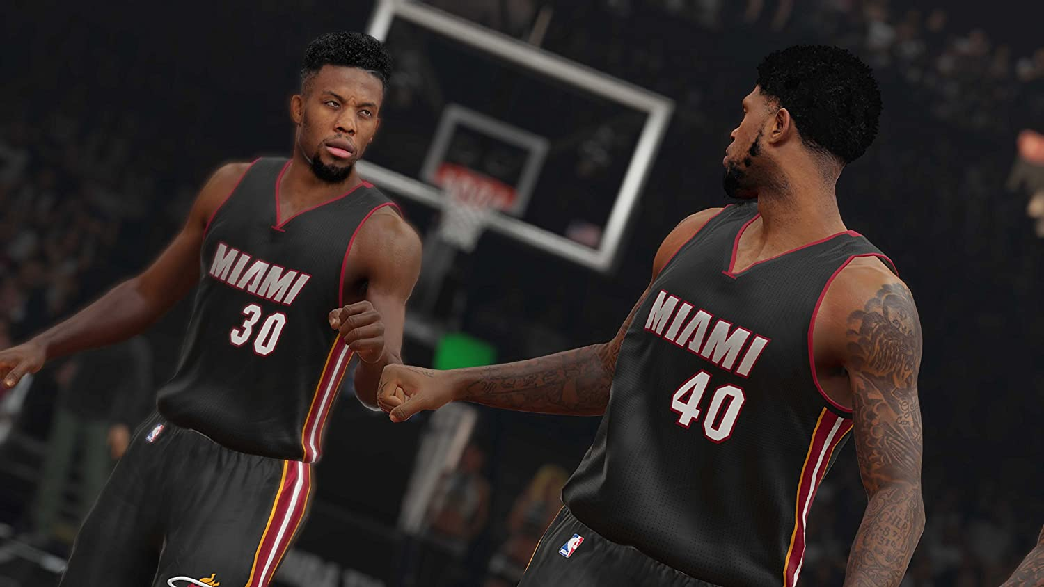 Zwei Basketballspieler in schwarzen Trikots mit Miami darauf. Einer schaut in die Kamera.