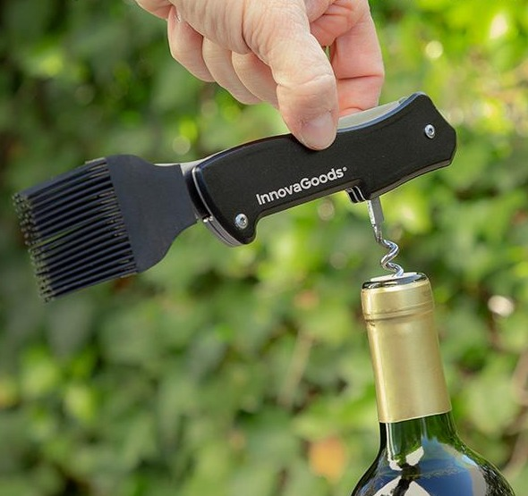 Weinöffner mit Bürste und Korkenzieher, von Hand gehalten, neben Weinflasche.