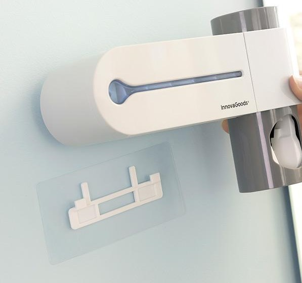 Un soporte para cepillos de dientes InnovaGoods blanco y gris montado en una pared azul claro.