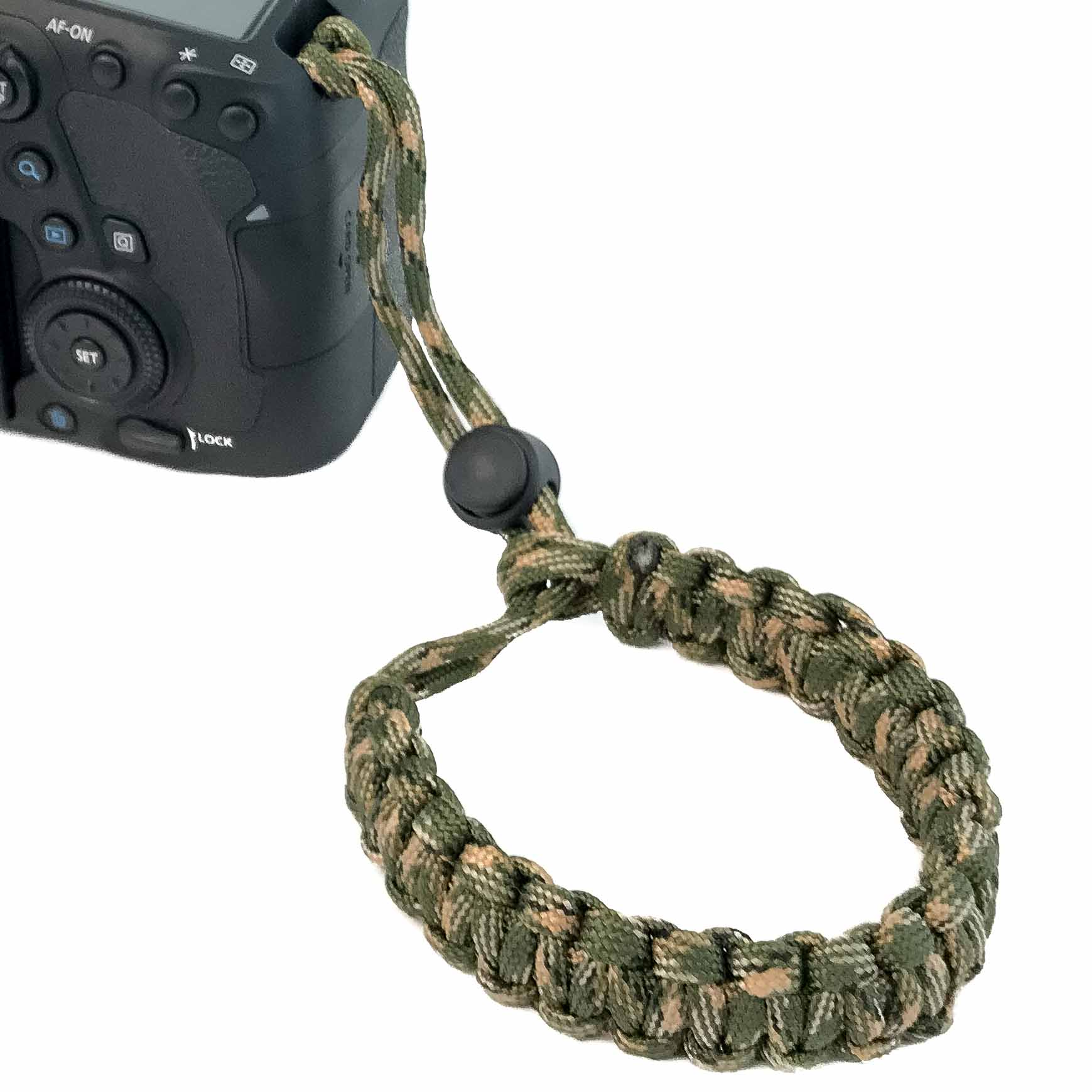 Kamera mit Tarnarmband. Das Armband ist geflochten.