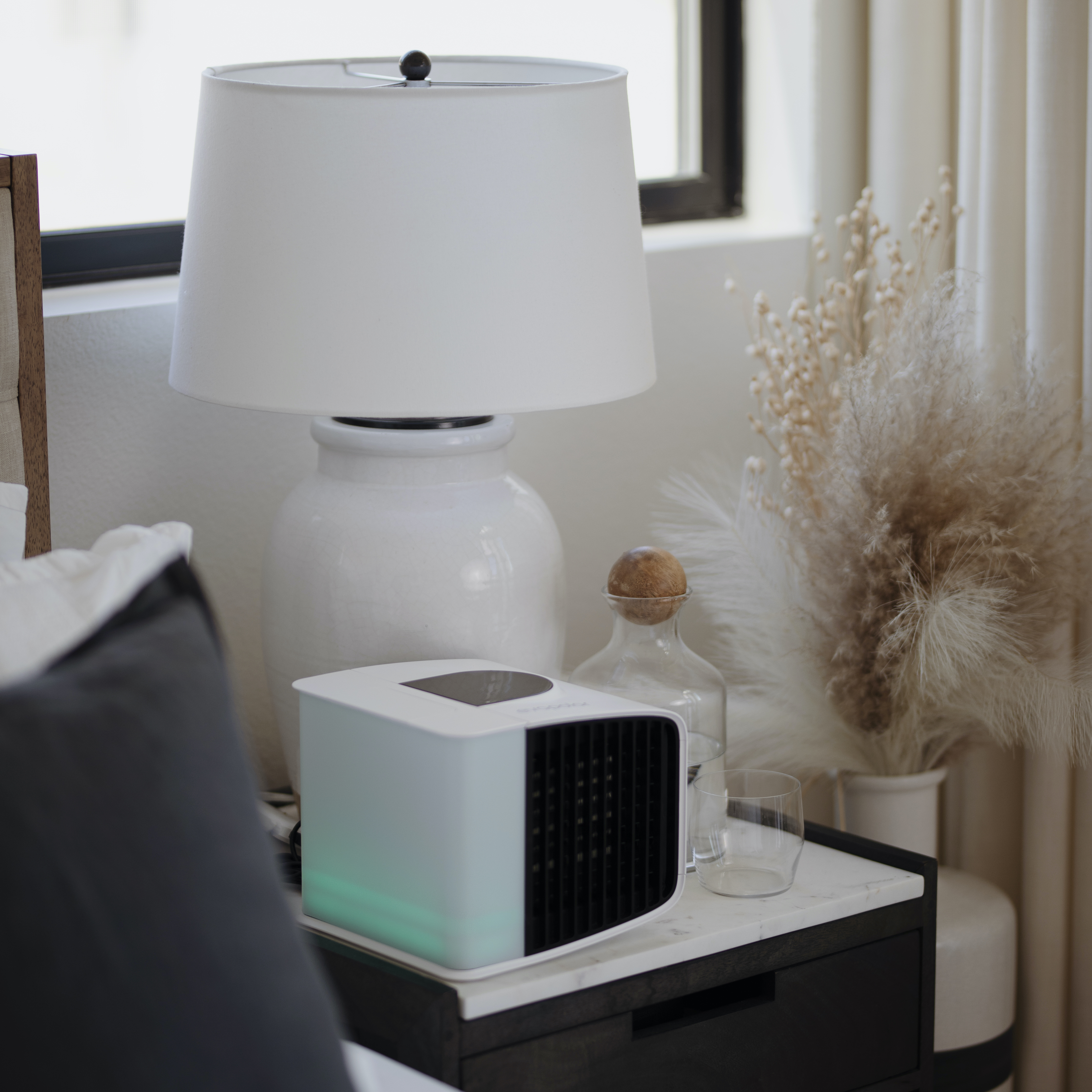 Schlafzimmer mit Lampe, Luftkühler, Dekoration und Bett.