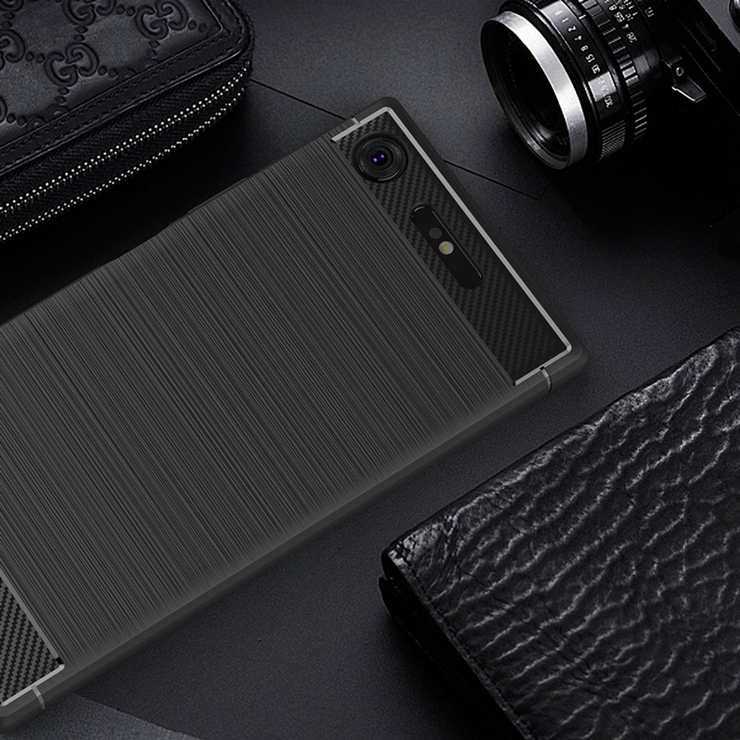 Schwarzes Telefon mit Carbonfaser und strukturierten Abschnitten. Ledergeldbörse und anderes Zubehör drumherum.