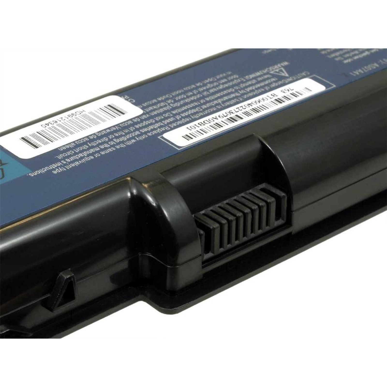Primer plano de una batería negra para portátil con pines de conector y etiquetas de advertencia.
