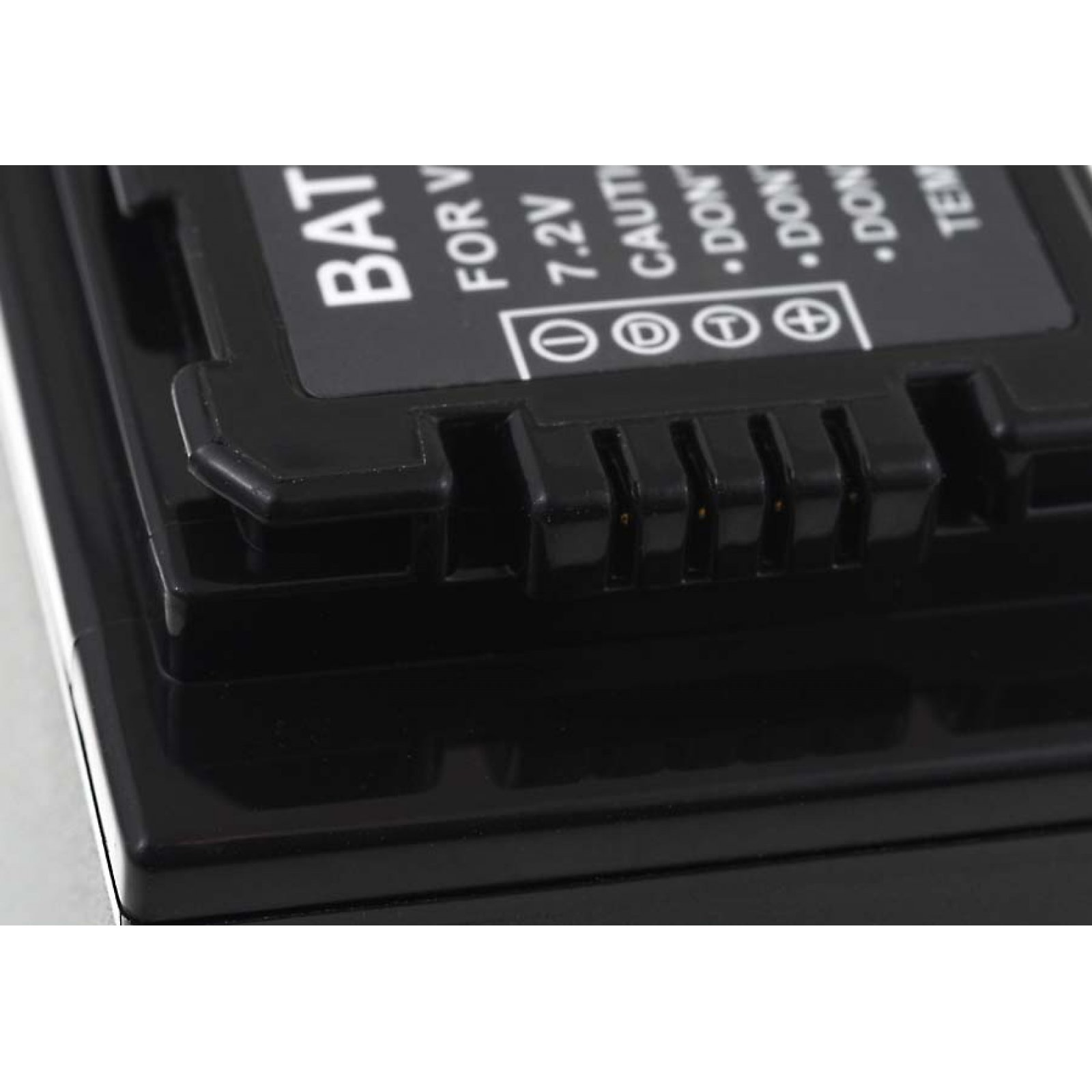 Primer plano de una batería negra con detalles de la etiqueta y un conector visible.