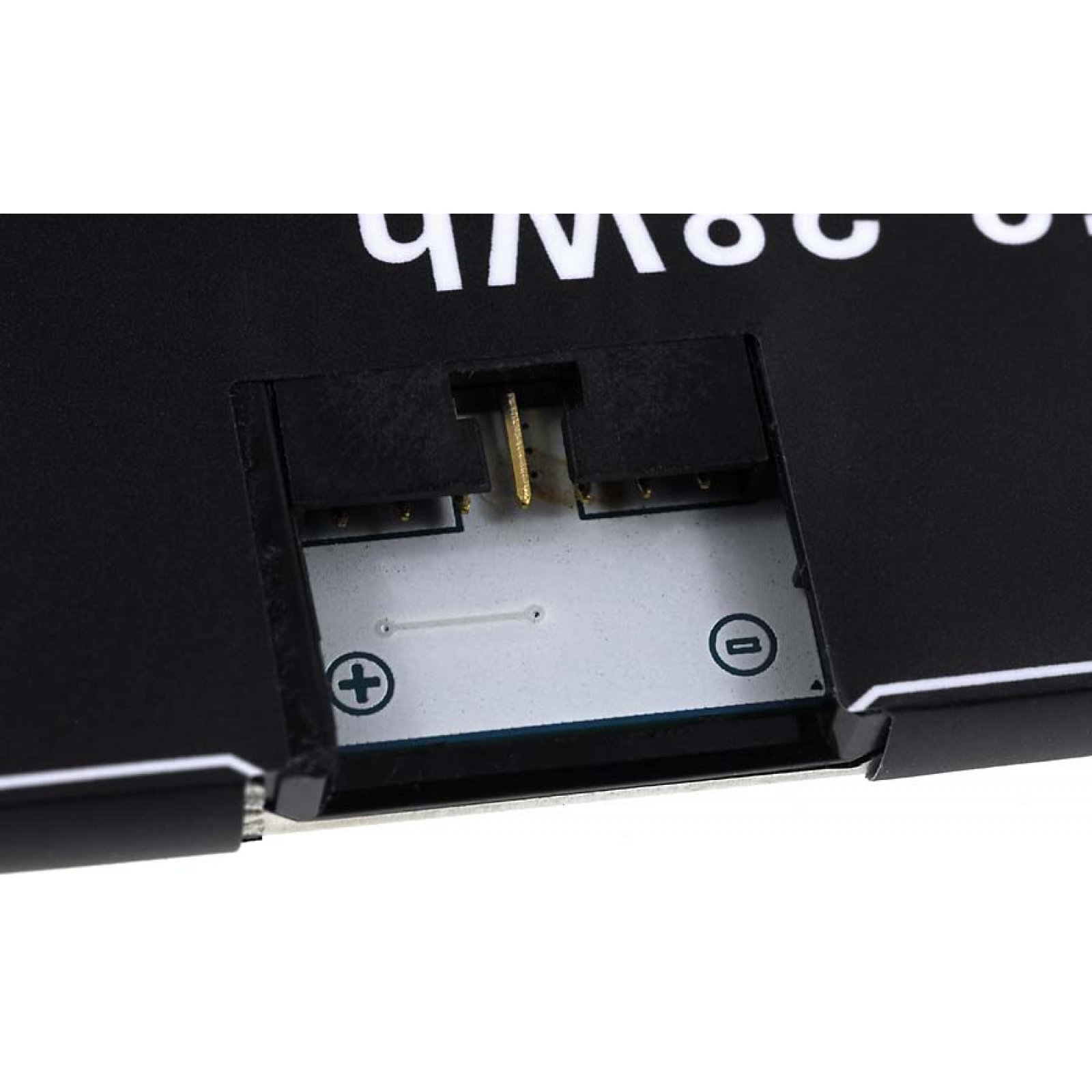 Primer plano del conector de la batería con símbolos más y menos en blanco.