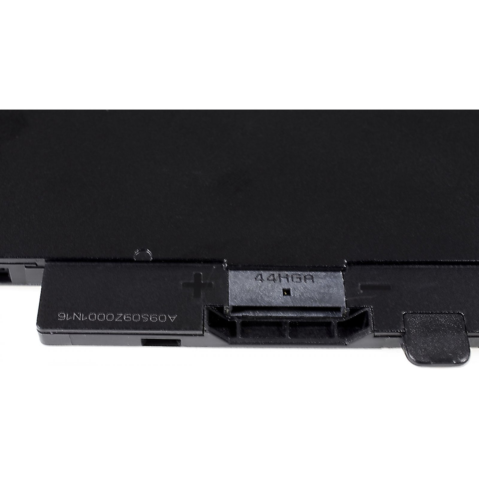 Primer plano de una batería rectangular negra con marcas y un área de conector.