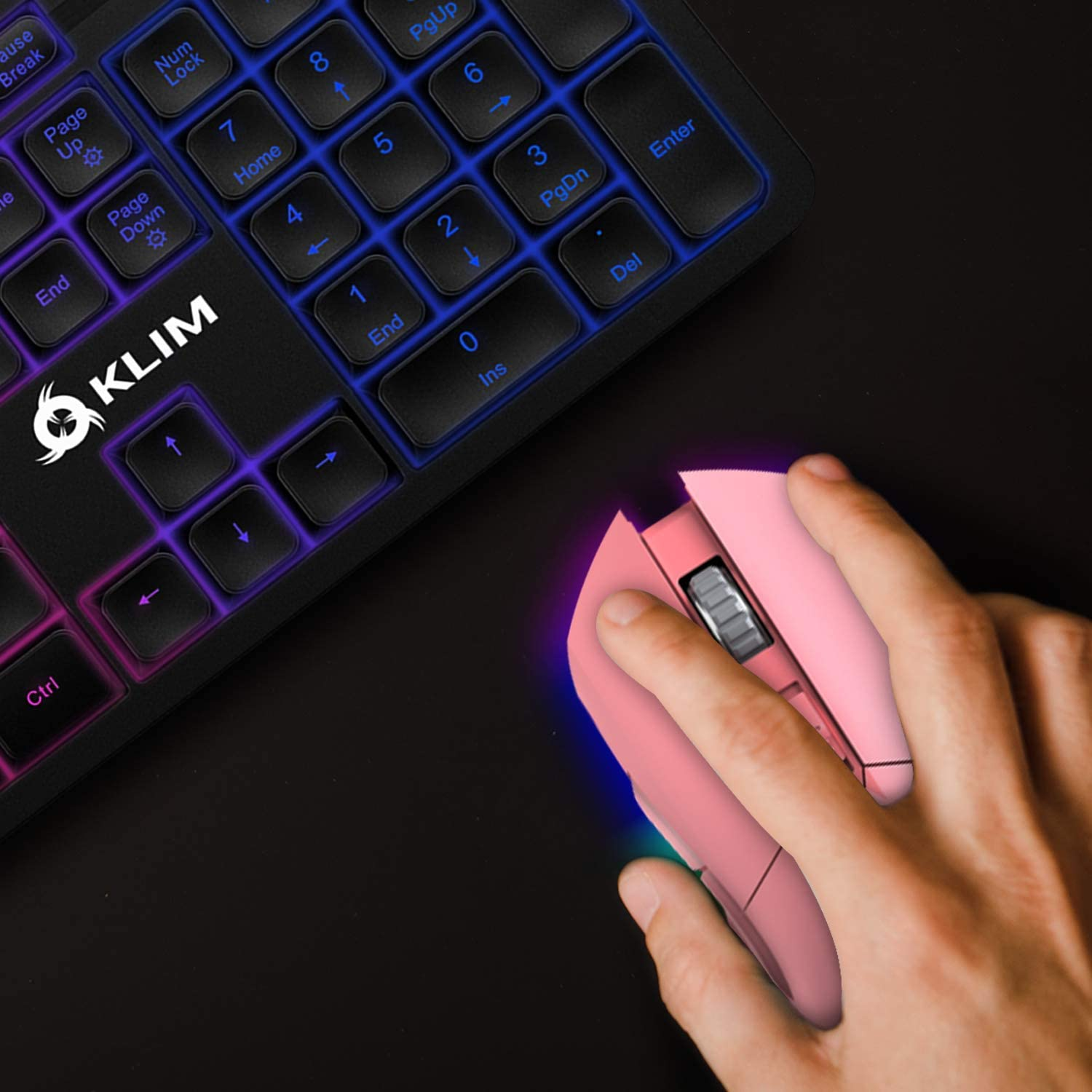 Rosa Maus neben einer Tastatur. Hand benutzt die Maus, leuchtende Lichter auf der Tastatur.