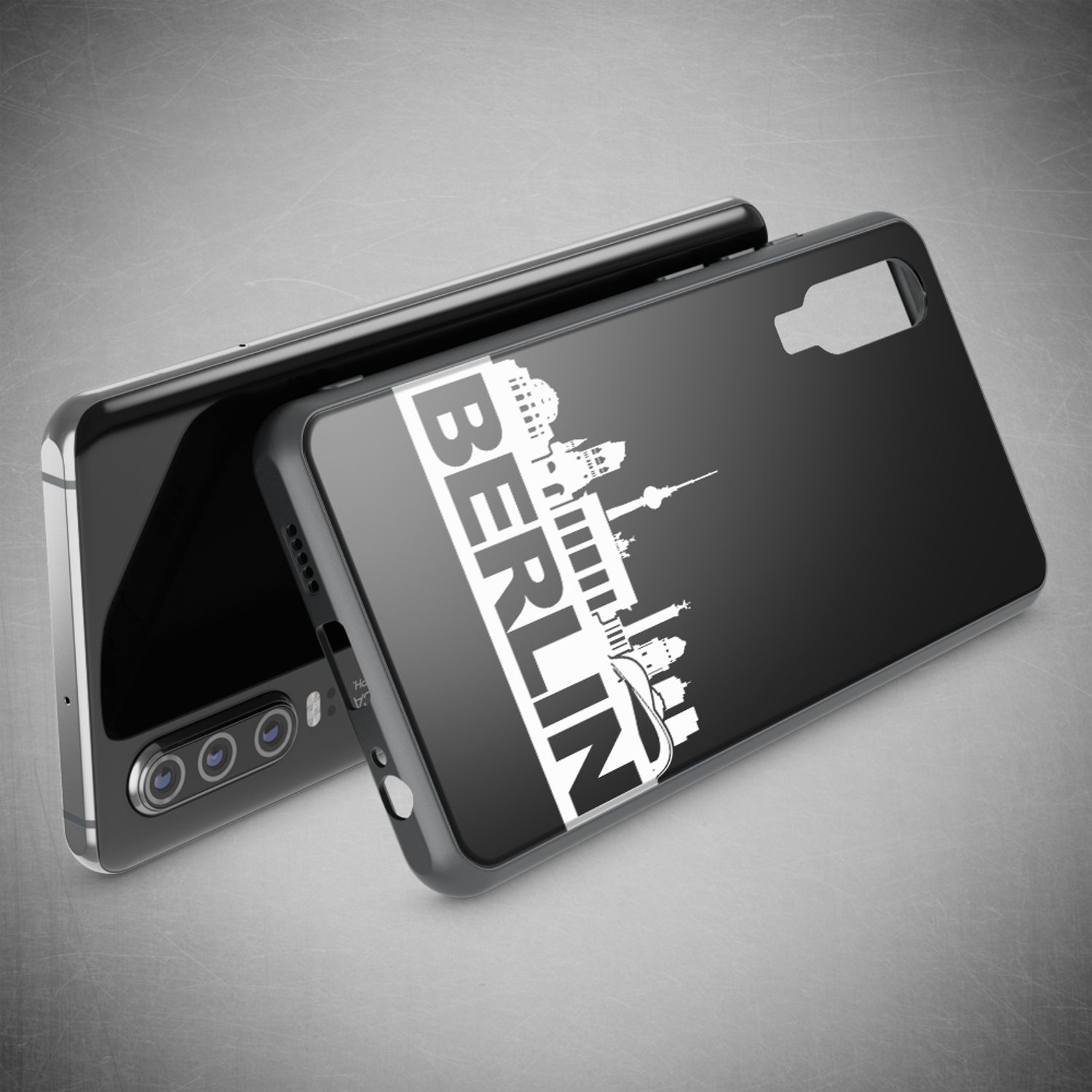 Coque de téléphone noire avec la ligne d'horizon de Berlin. Le téléphone est sur une surface grise. Autre téléphone en arrière-plan.