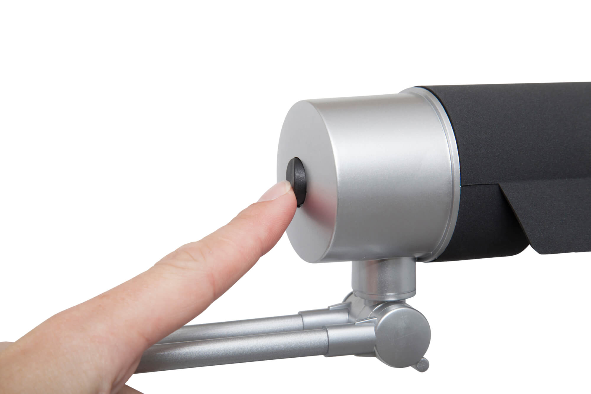 Palec naciska czarny przycisk na srebrno-czarnym urządzeniu na białym tle.