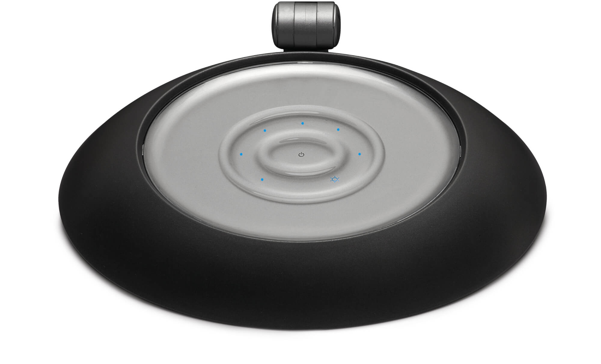 Okrągłe, czarne urządzenie ze srebrną, okrągłą górą. Na górze znajduje się przycisk.