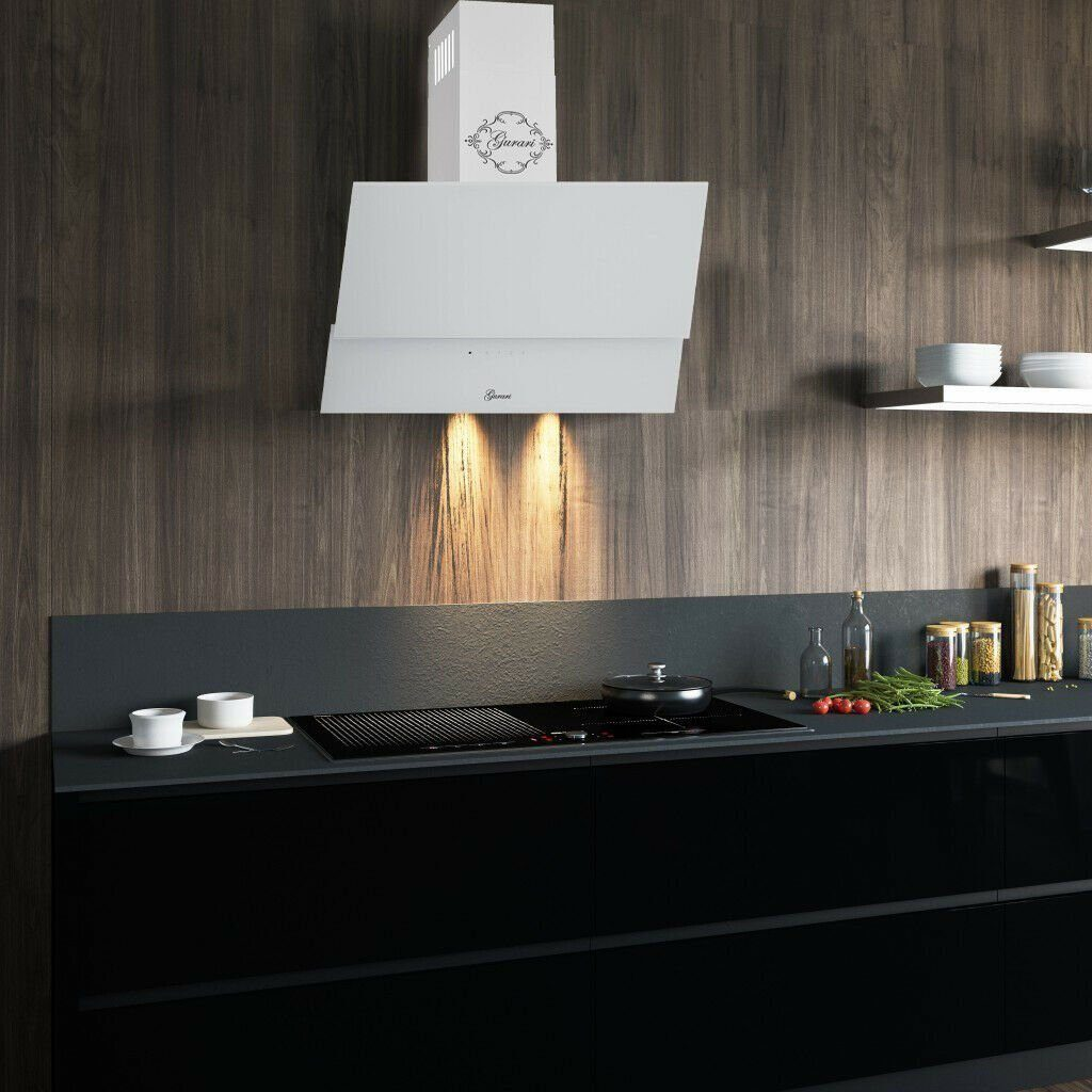 Una campana de cocina blanca con una encimera negra y una estufa negra. La pared es de madera y la cocina parece moderna.