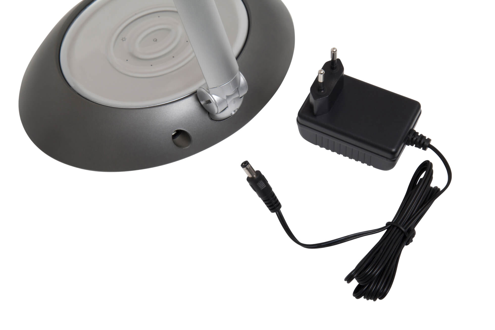 Lampa z adapterem i kablem zasilającym. Lampa jest po lewej stronie.