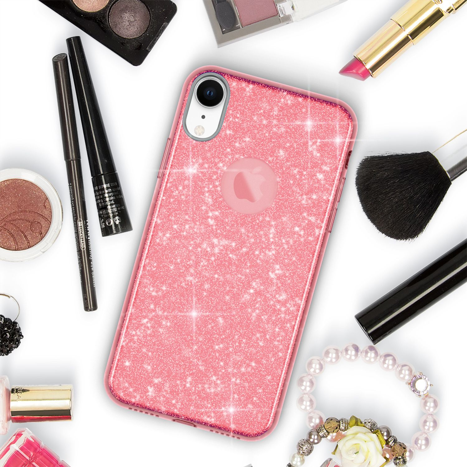 Eine pinkfarbene Glitzer-Handyhülle auf einem Tisch mit Make-up-Artikeln. Es gibt Lidschatten, Mascara und einen Lippenstift.