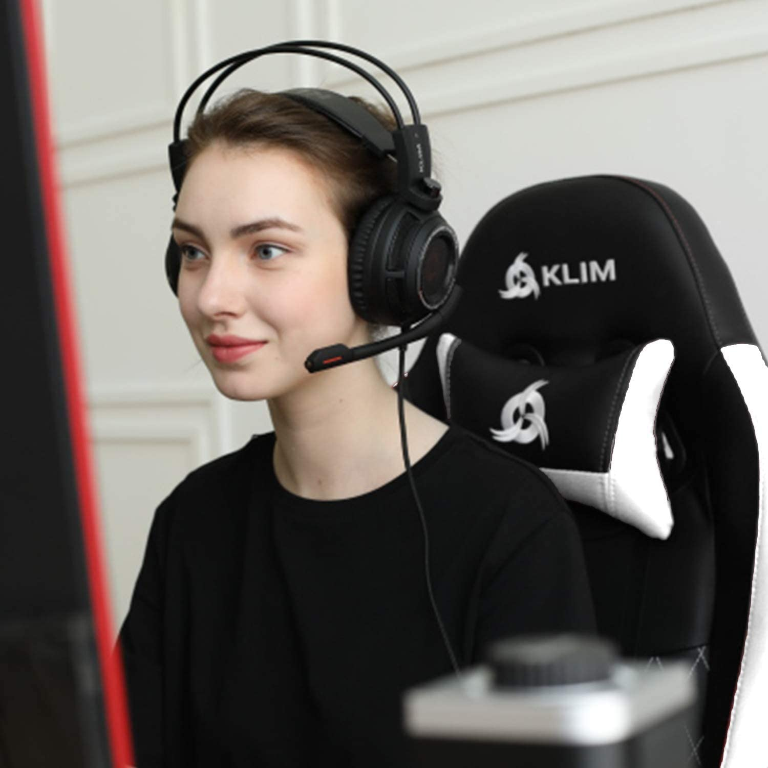 Frau mit Kopfhörern und Mikrofon, die vor einem Computer spielt.