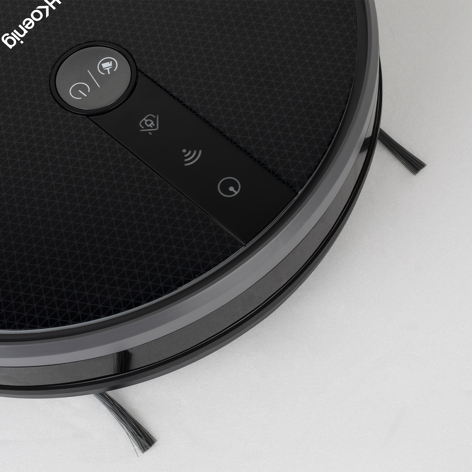 Czarny robot odkurzający z szarą obwódką, widok z boku.