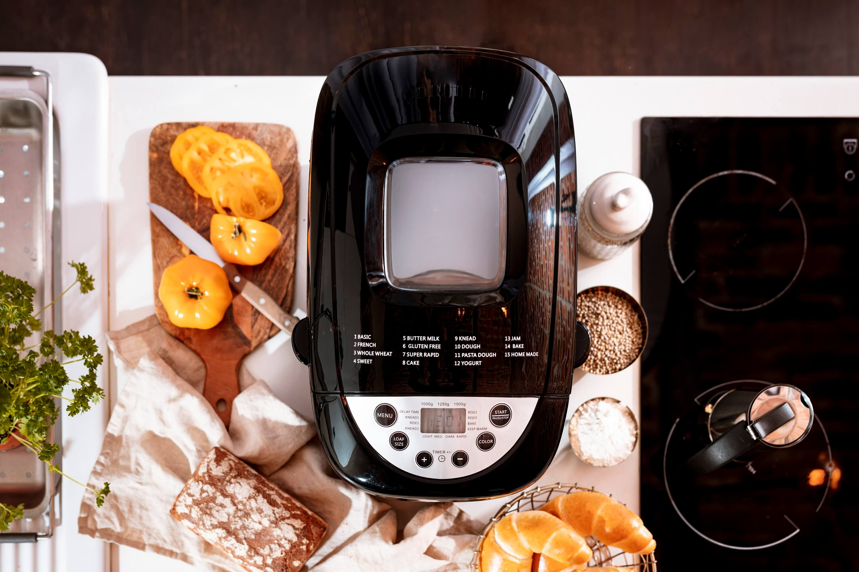 Draufsicht auf eine Brotbackmaschine, mit Zutaten und Brot auf der Theke.
