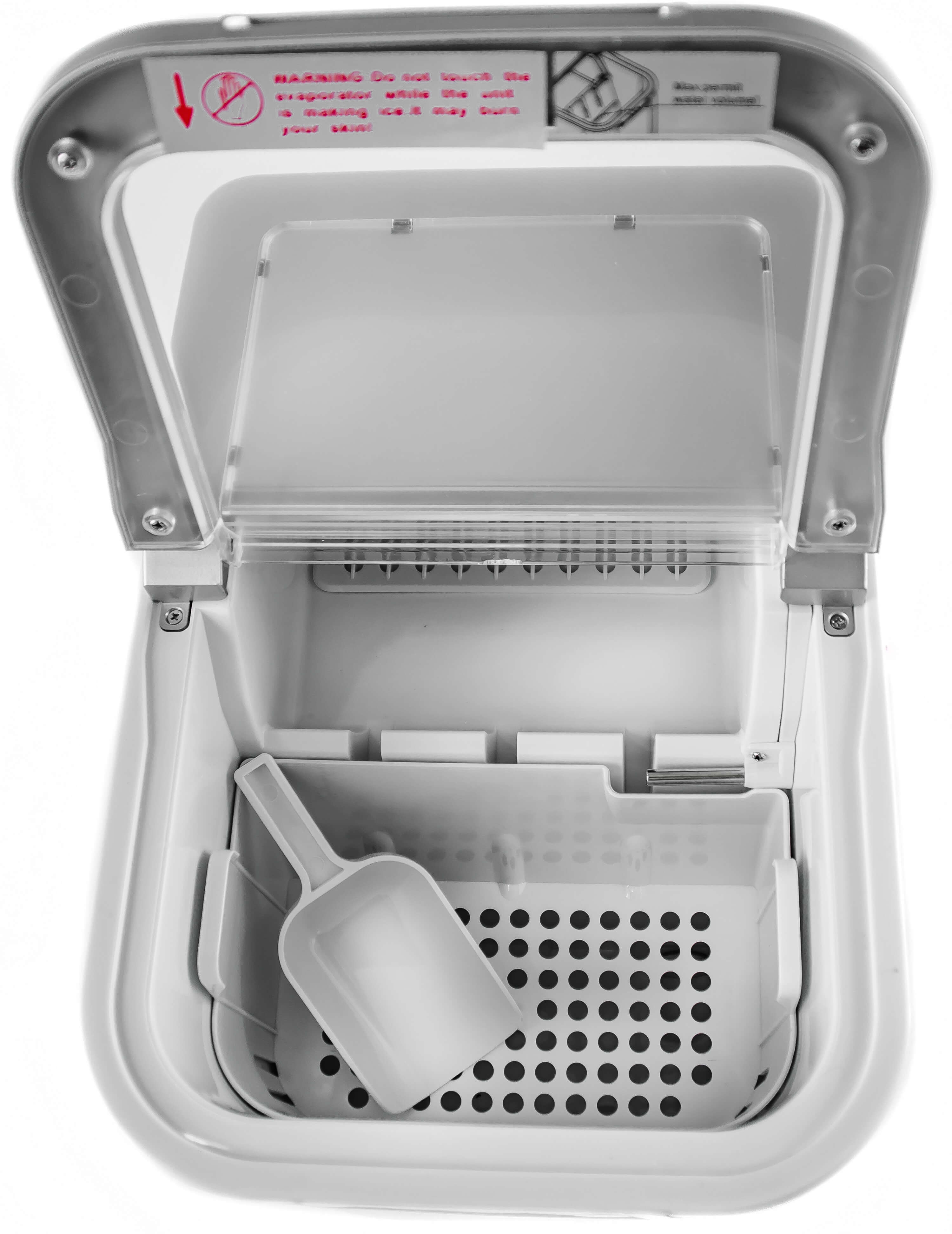 Otwarta biała kostkarka do lodu, odsłaniająca tackę na lód i szufelkę. Widoczna etykieta ostrzegawcza.