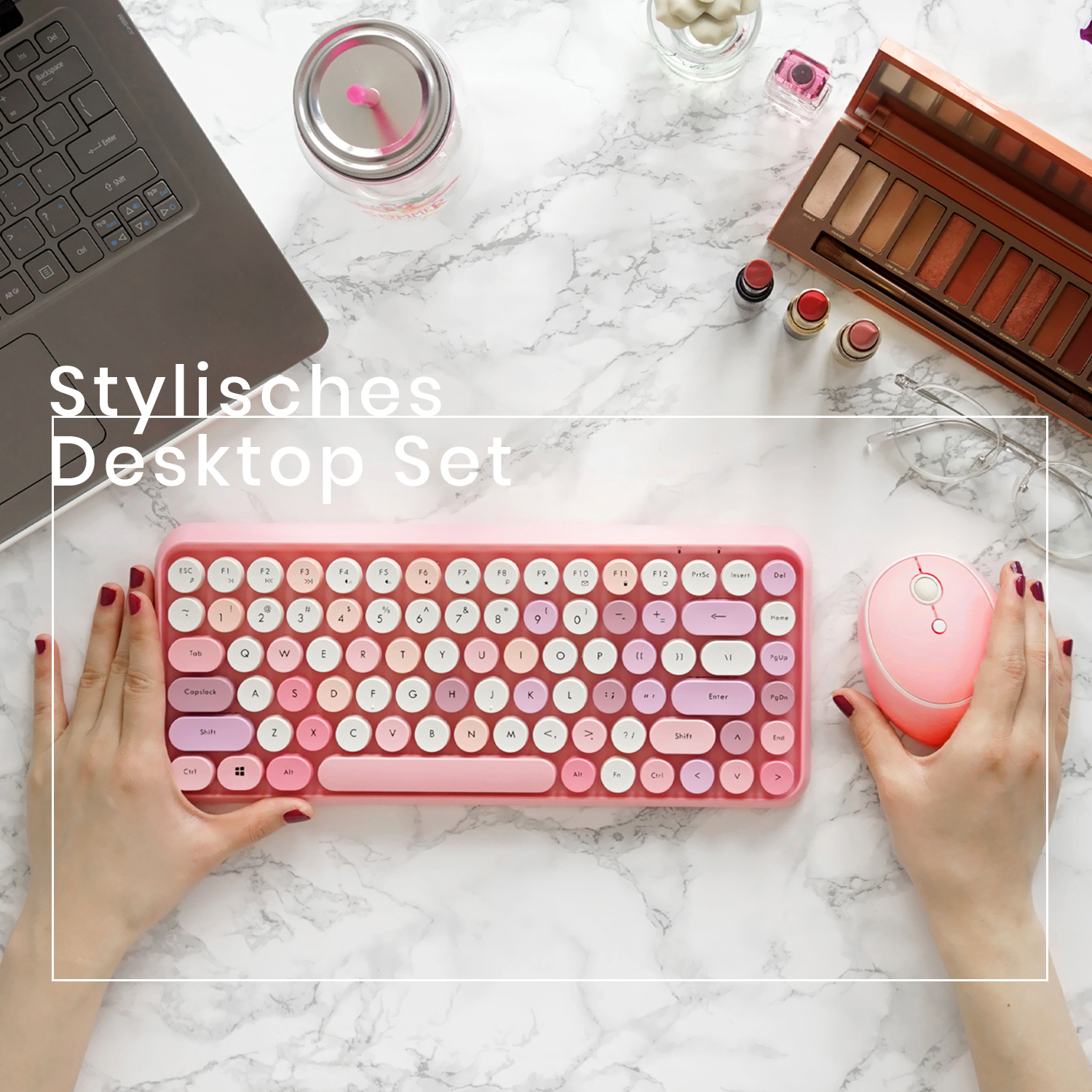 Ein rosa Schreibtisch-Set mit Tastatur, Maus und Zubehör auf einer Marmoroberfläche.