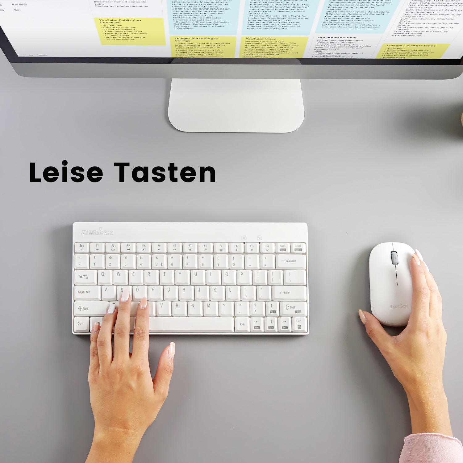 Eine weiße Tastatur und Maus auf einem grauen Schreibtisch mit dem Text 'Leise Tasten'.