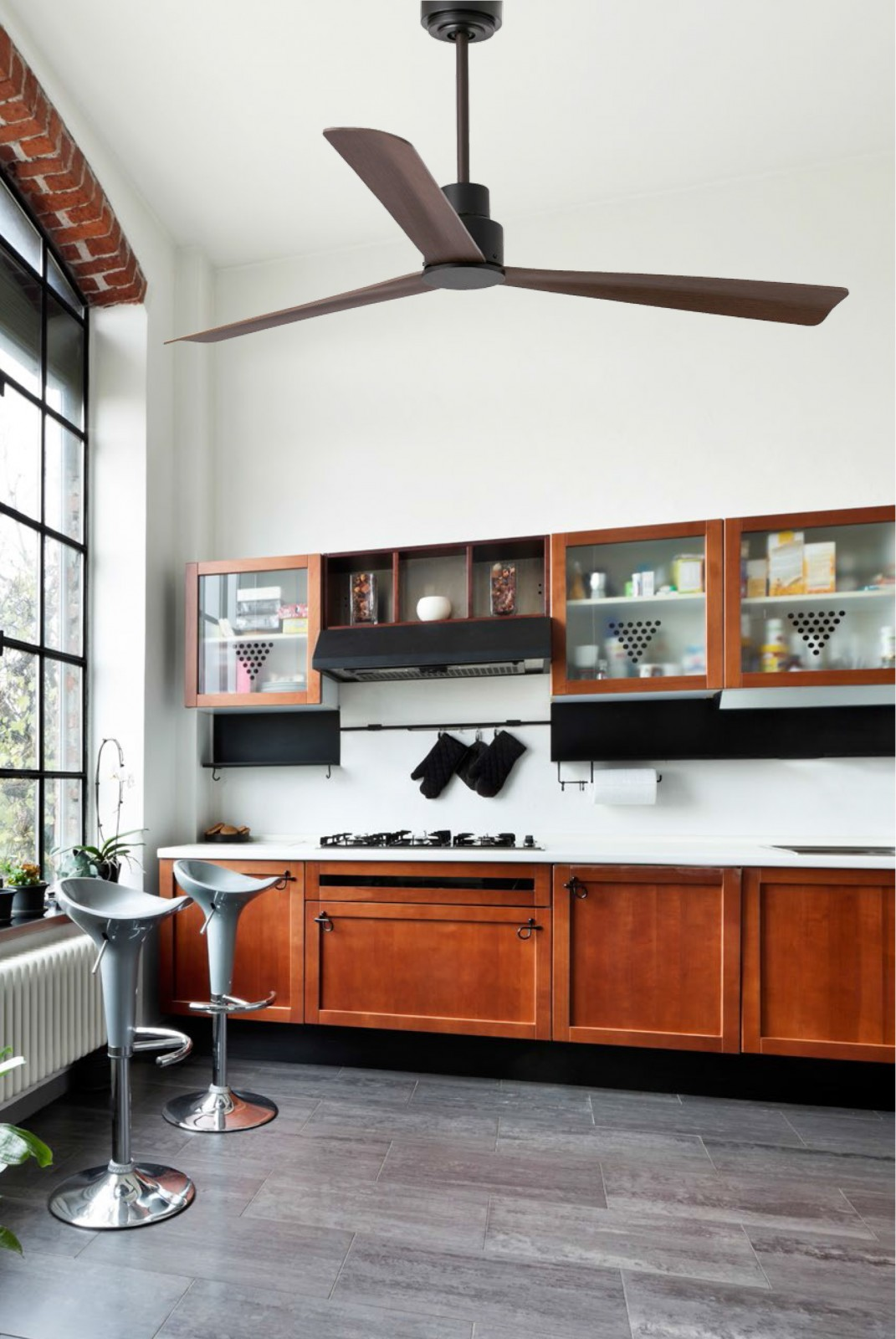 Una cucina moderna con un ventilatore a soffitto marrone, mobili in legno e sgabelli grigio chiaro.