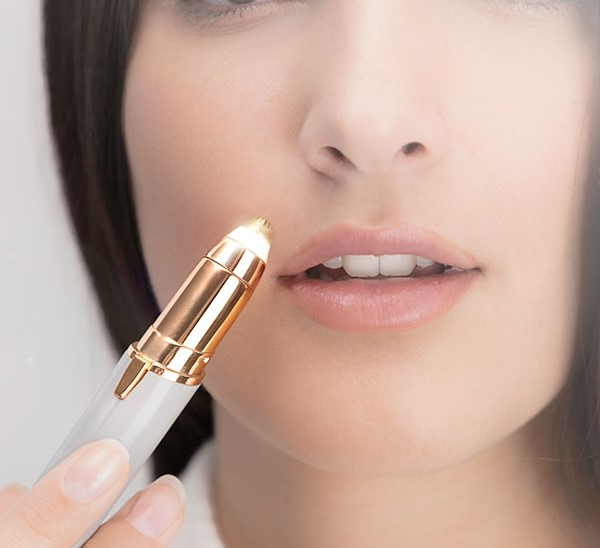 Frau, die einen Gesichtsepilierer in der Nähe ihrer Lippe benutzt.