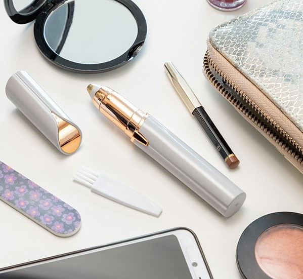 Kosmetik und Beauty-Werkzeuge auf weißer Oberfläche: Spiegel, Trimmer etc.