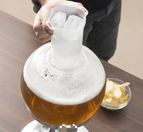 Person gießt Eis in einen Bierausspender mit Bier und Chips in der Szene.