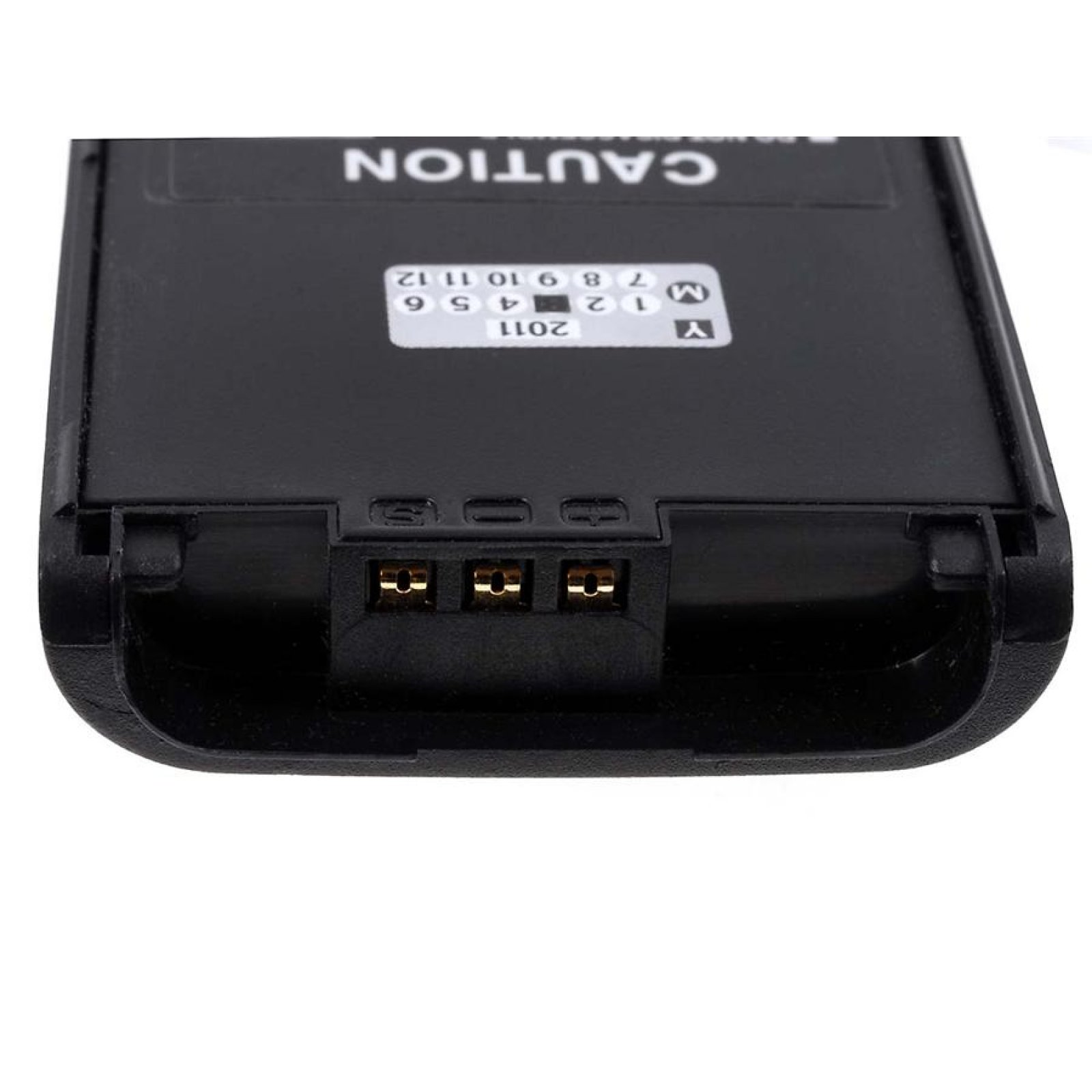 Conector de batería negro con tres pines dorados. Precaución y etiqueta del año visibles.