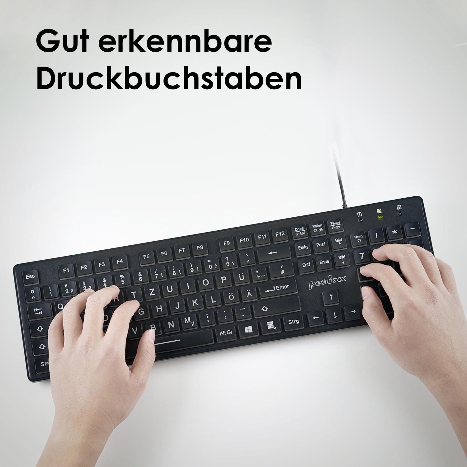 Hände, die auf einer schwarzen Tastatur mit weißen Tasten tippen, mit dem Text "Gut erkennbare Druckbuchstaben".