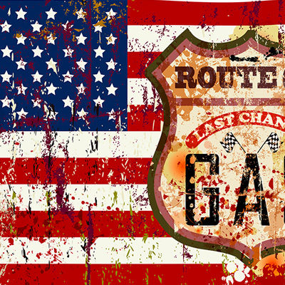 Eine amerikanische Flagge mit einem Route 66-Schild. Die Flagge ist verwittert.