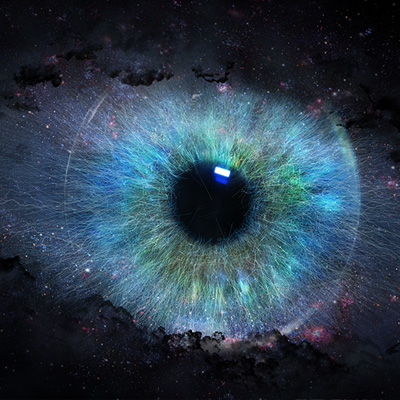 Primo piano di un occhio umano, con un'iride blu vibrante circondata da uno spazio scuro e stellato.