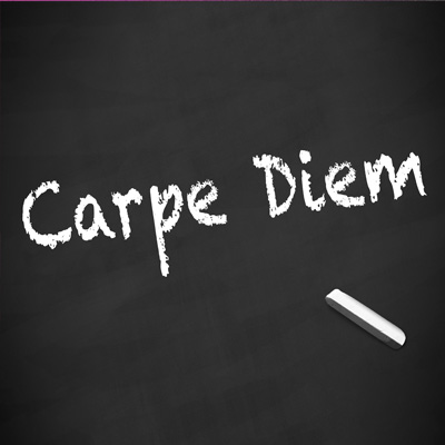 'Carpe Diem' auf einer Tafel geschrieben, daneben Kreide.